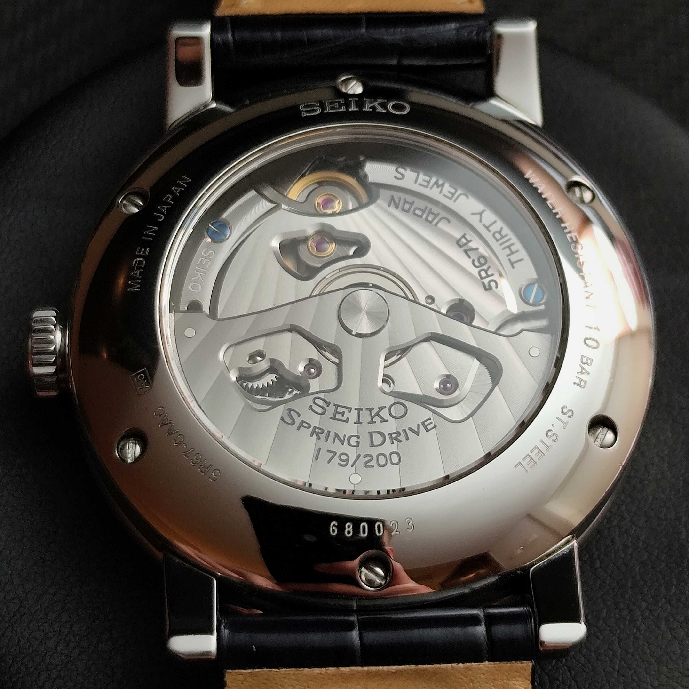 Seiko watch with black strap and visible mechanical components on a dark background