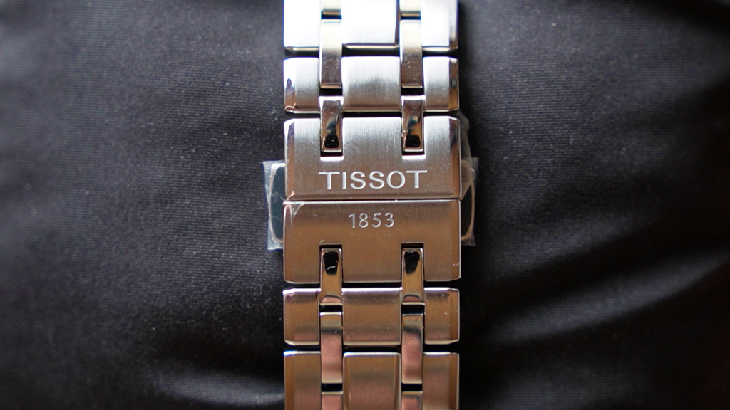Silver Tissot watch strap on a black background