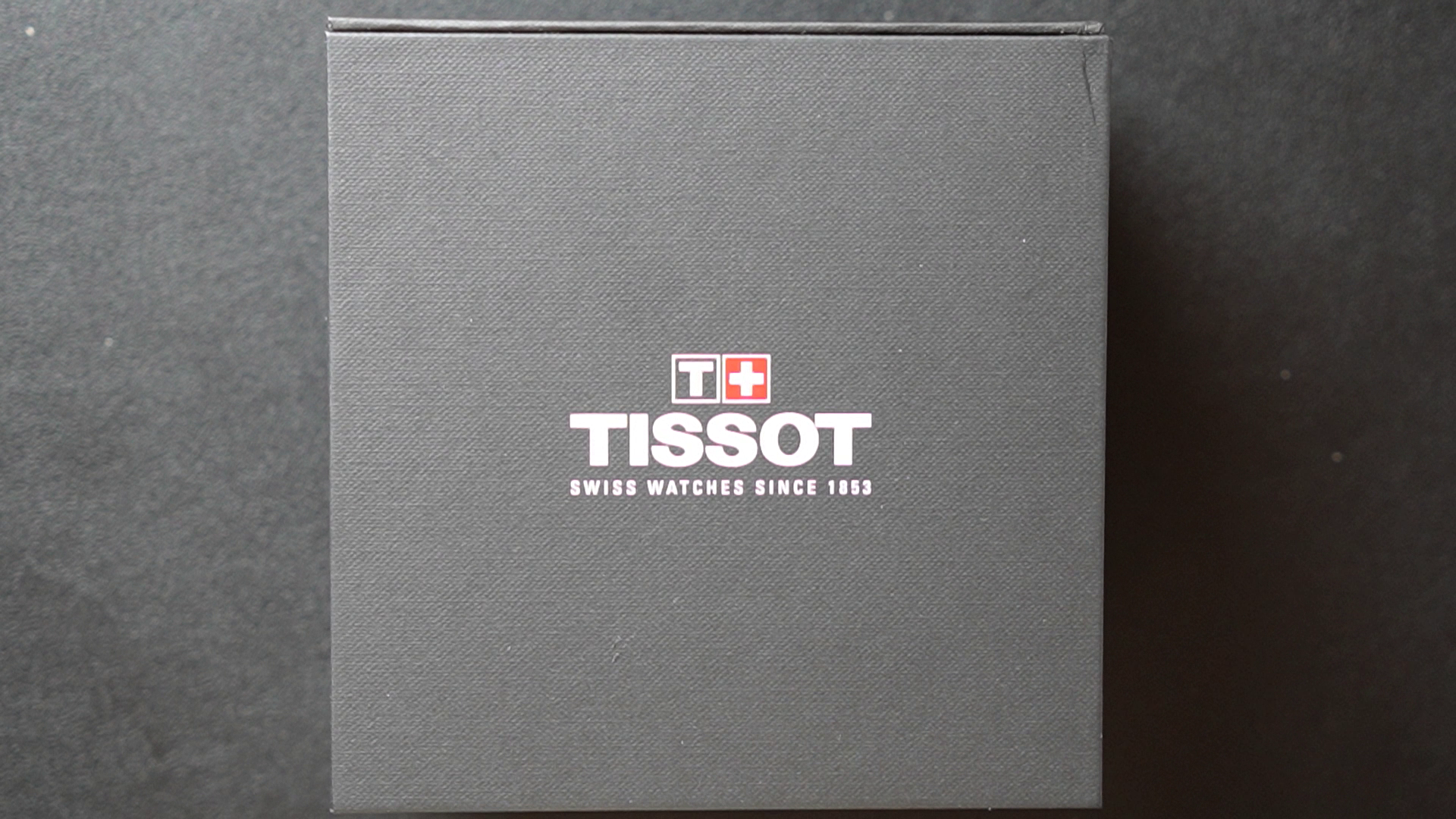 Tissot watch box with brand logo on a dark background