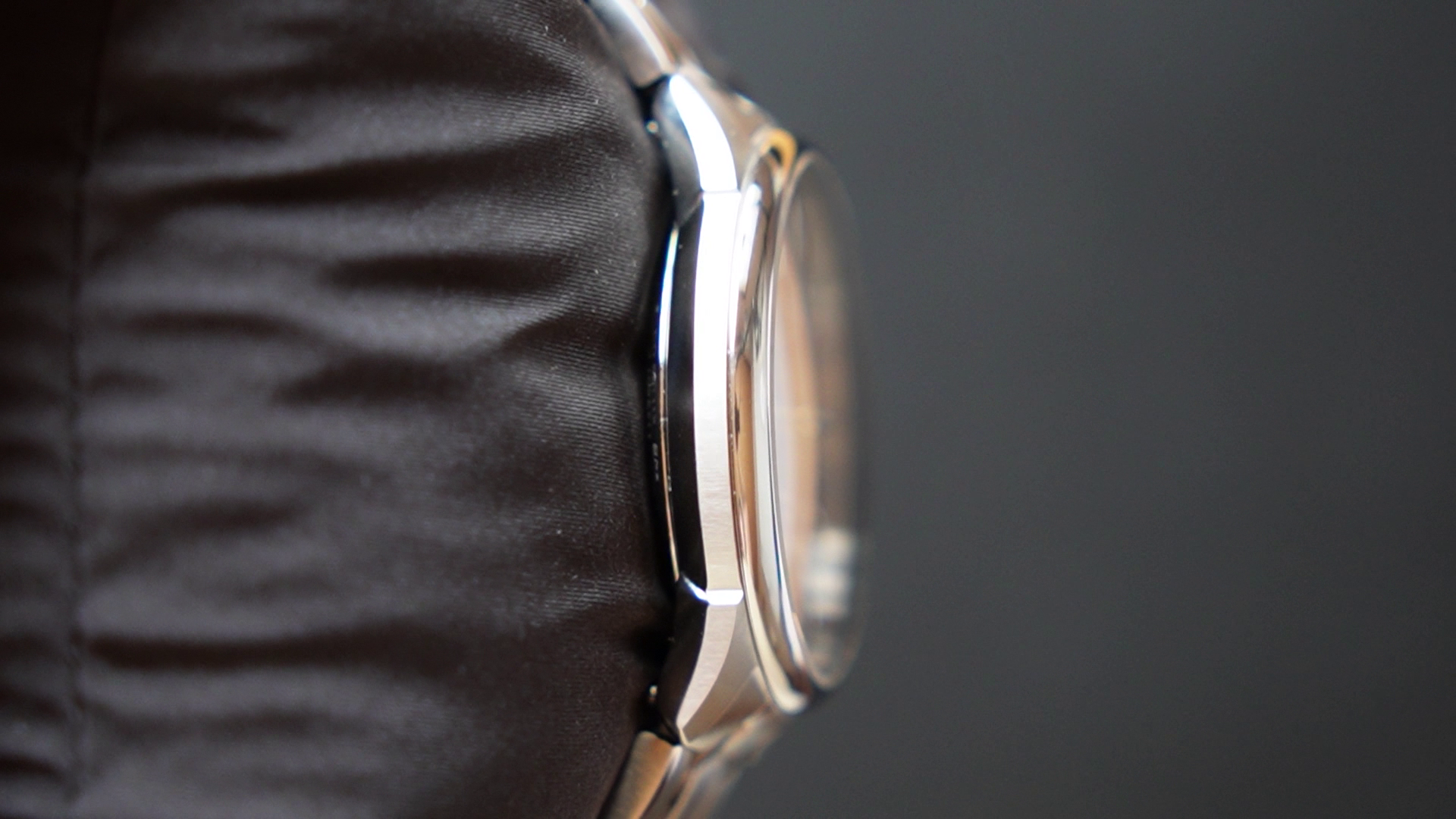 Close-up of a watch with a dark strap on a dark background